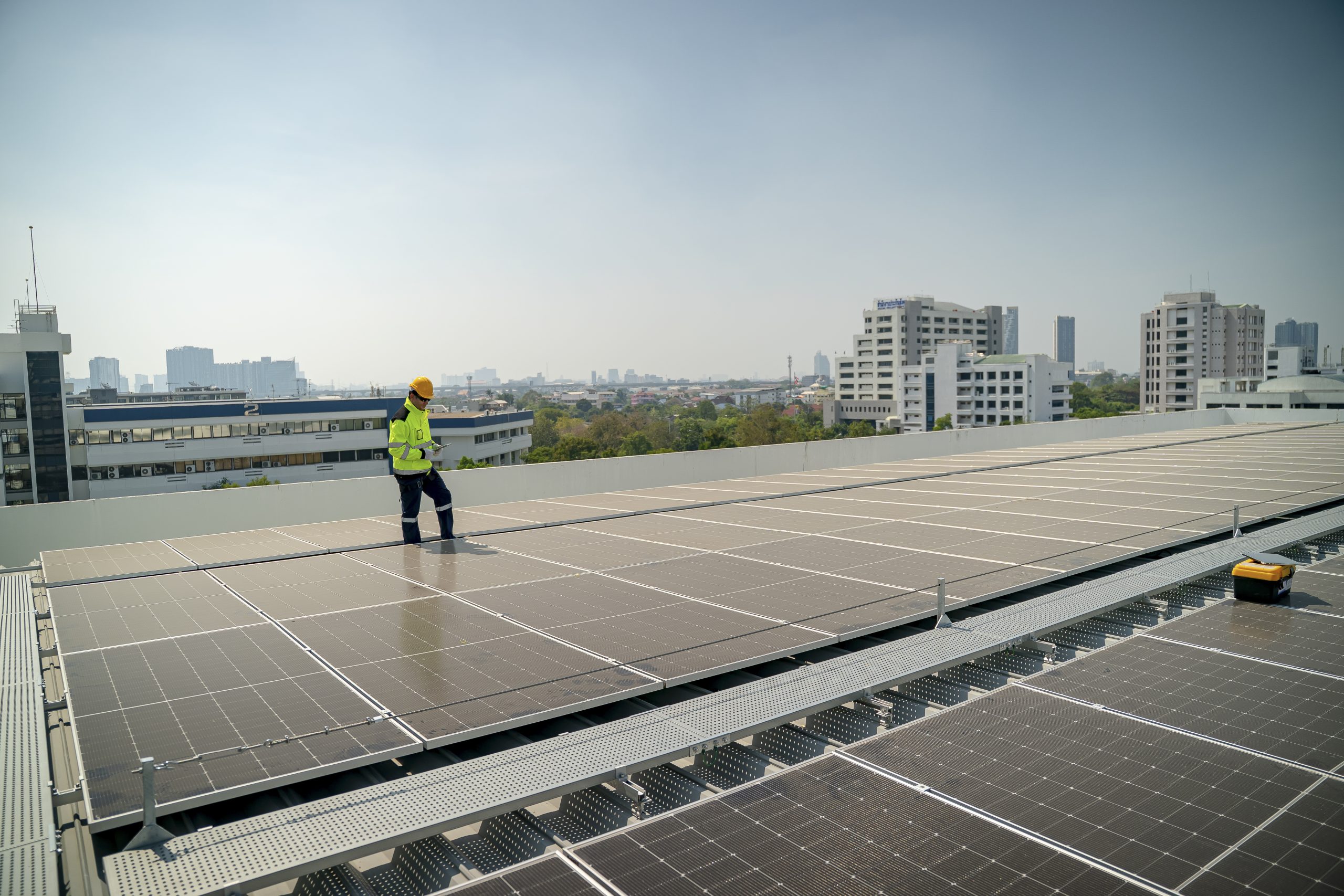 Solar panel installation on a rooftop in an urban setting during daylight hours